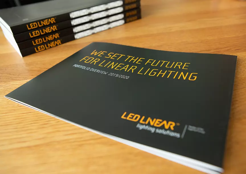 LED Linear Portfolio Overview Cover, im Hintergrund liegen säuberlich gestapelte Kataloge