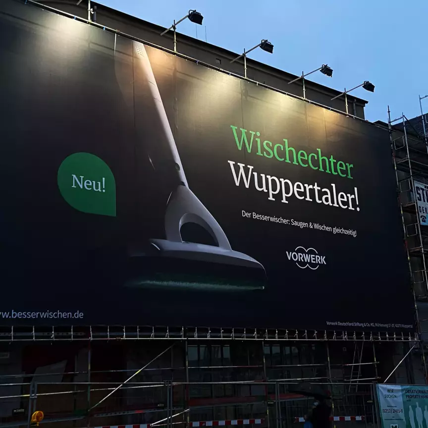 Vorwerk Besserwischer Werbebanner vor einer in der Restauration befindlichen Hausfassade in Wuppertal