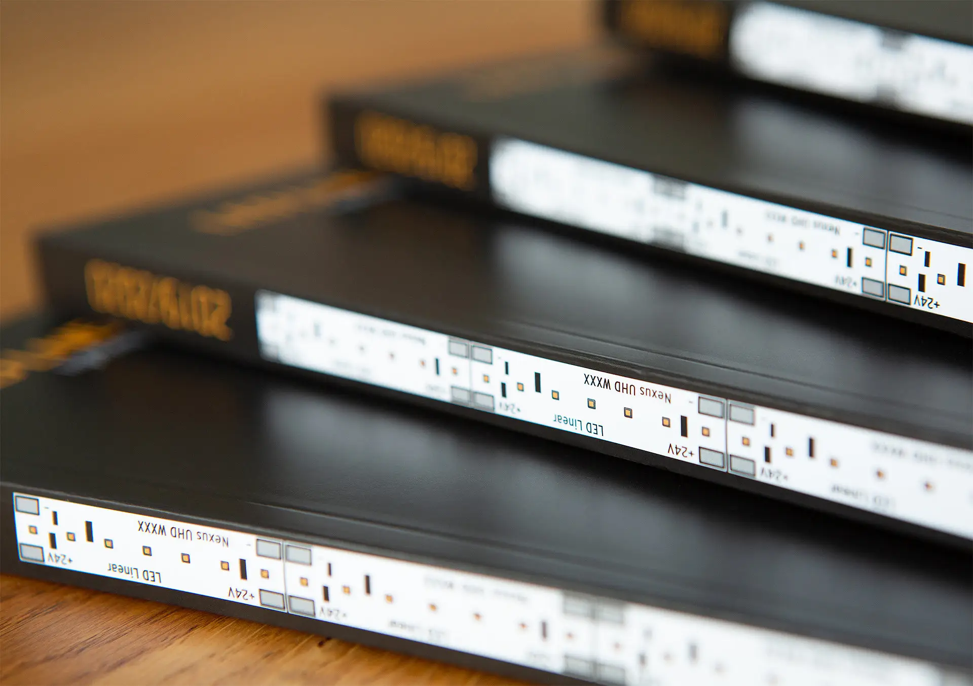 Branding LED Linear: Close-up of stacked black catalogs with LED strip graphics on the spines