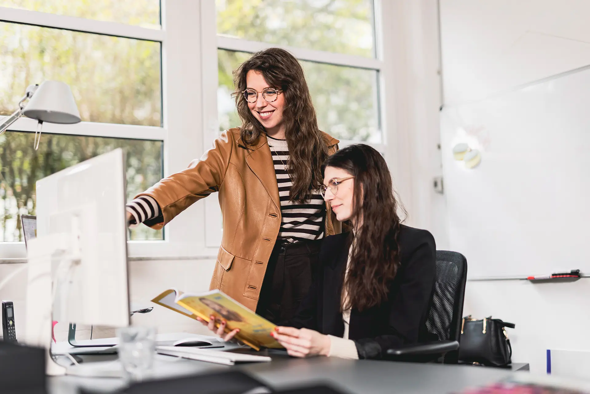 Teammeeting bei BECKDESIGN: Mitarbeiterin bespricht Projektdetails mit Kollegen für eine Social Media Marketing Maßnahme