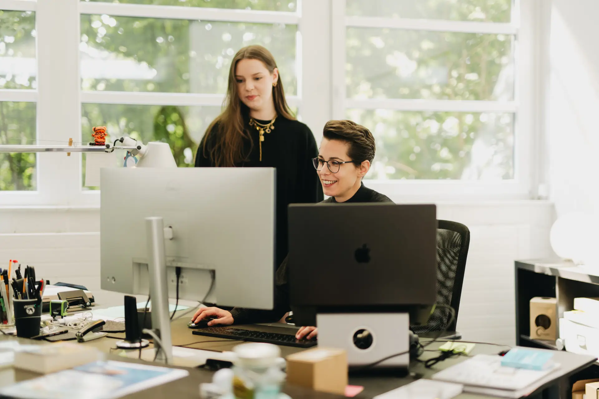 Zwei Mitarbeiterinnen der Agentur BECKDESIGN arbeiten gemeinsam am Bildschirm bei der Planung einer Social Media Strategie