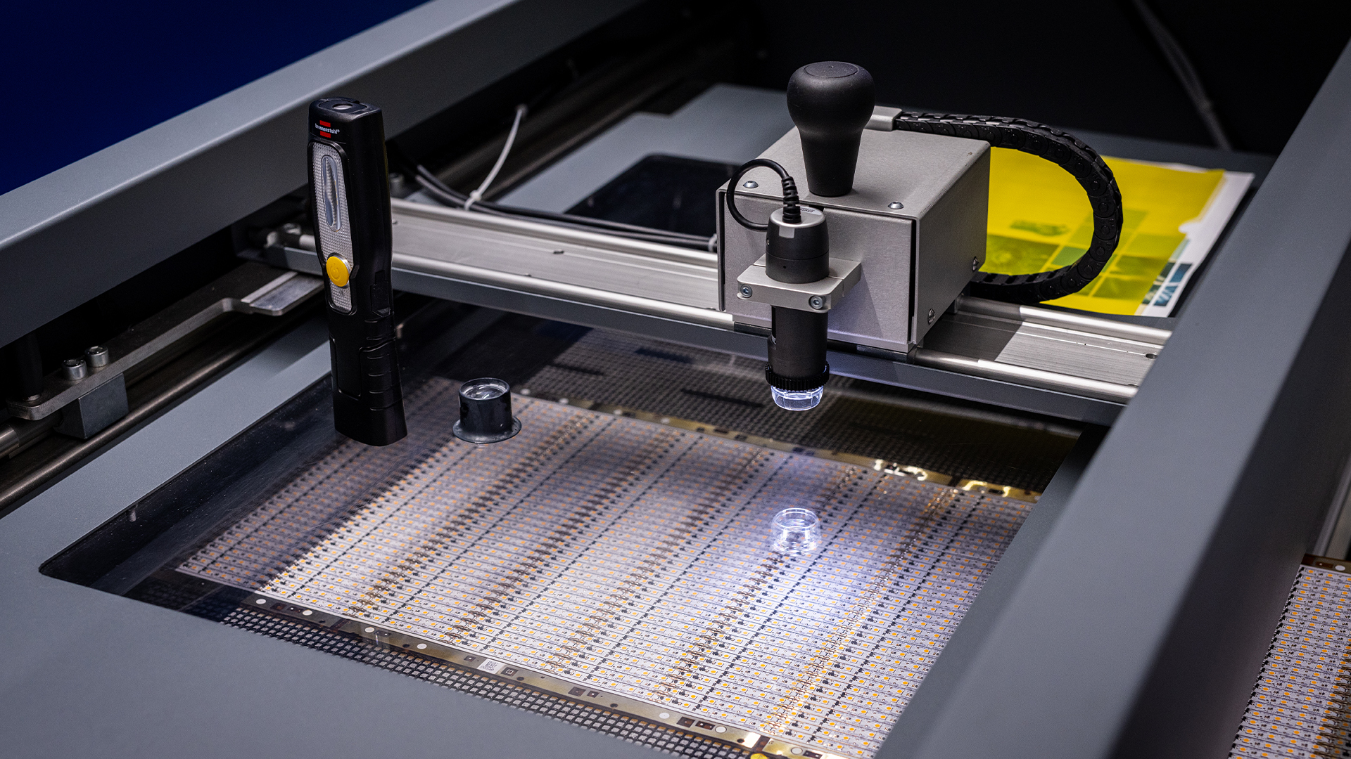 Digitales Mikroskop an einer Prüfstation über einem beleuchteten Nutzen mit LED-Platinen